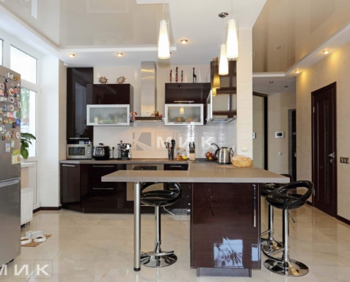 Кухня в сучасному стилі з блискучими поверхнями та дизайнерським освітленням від MIK Елегантна кухня з темними шафами та мармуровою стільницею від MIK