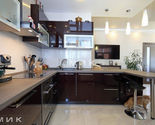 Сучасна кухня з вбудованою технікою Інтер'єр кухні з високим блиском шаф та центральним островом для сніданку від MIK