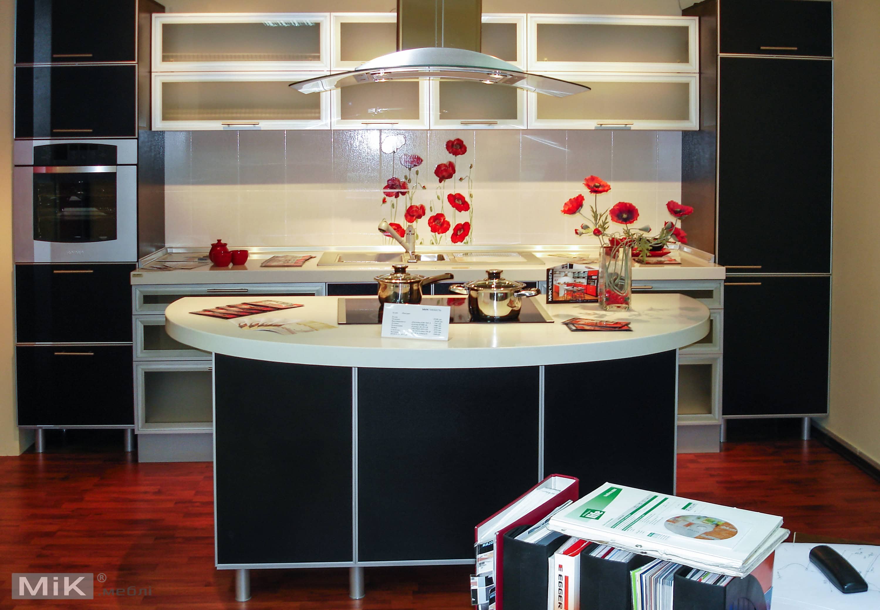 1_Черная кухня ДСП в рамке Современная кухня с черными шкафами и белыми рабочими поверхностями, украшенная красными акцентами.
