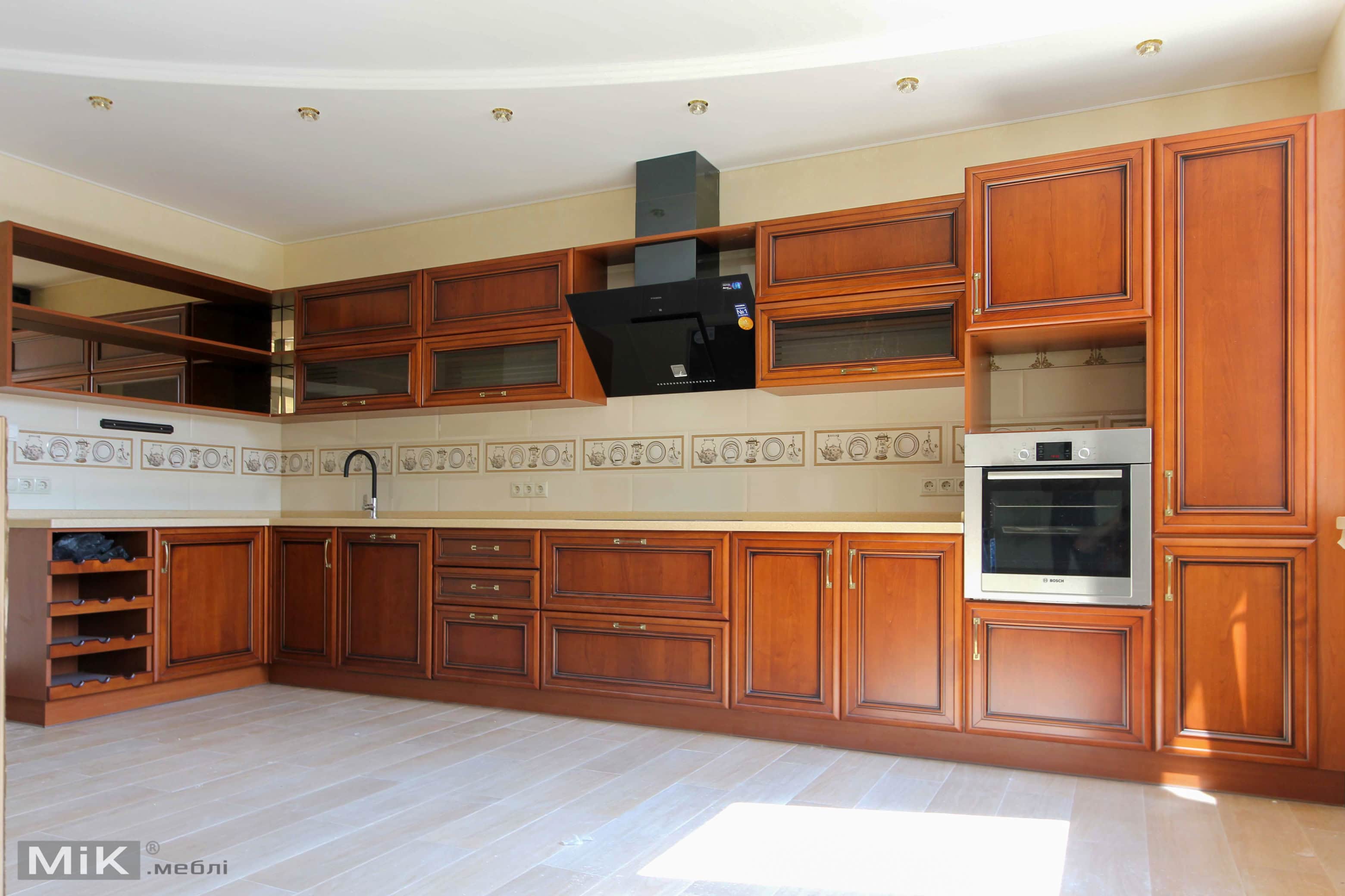 Классическая кухня с натуральным фасадом Интерьер кухни с роскошными деревянными шкафами и современными удобствами.