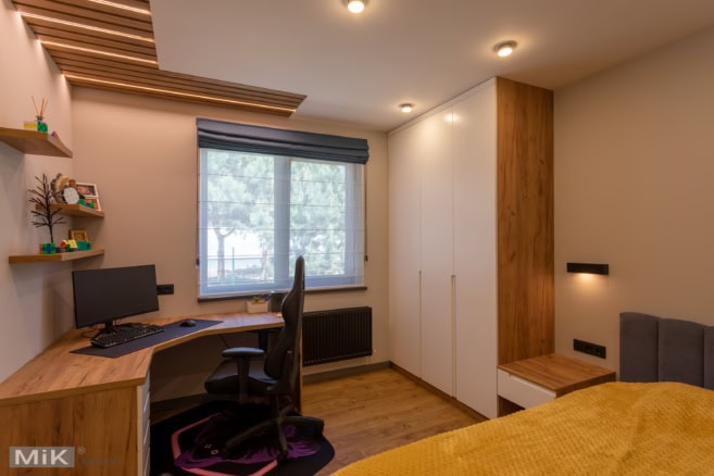 мебель для подростка в детской комнате: рабочий стол, шкафы и декоративные панели на потолке с подсветкой