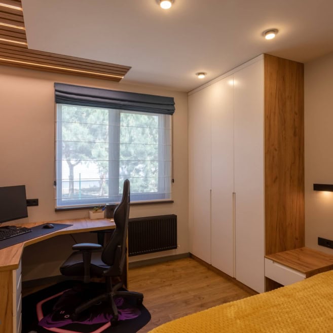 мебель для подростка в детской комнате: рабочий стол, шкафы и декоративные панели на потолке с подсветкой