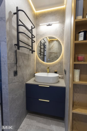 Синя тумба та кругле дзеркало в санвузлі на замовлення